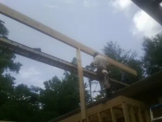 Carpenter setting a ridge beam over a new addition frame — Ice Dam Removal by Roofing Brothers in Kenyon