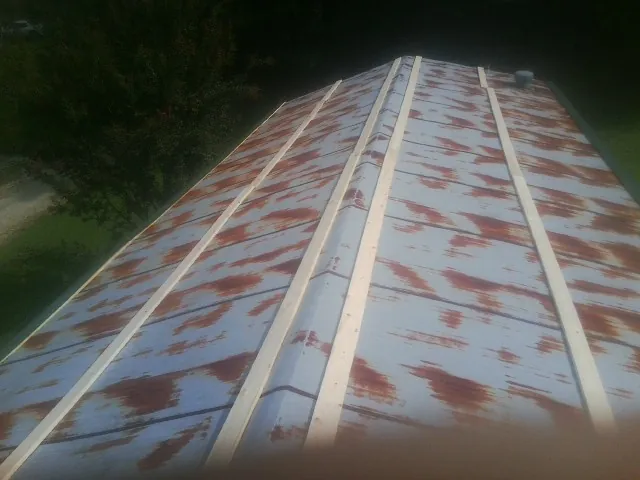 Rusted metal roof panels with new wood purlins before replacement — Storm Damage Roof Repair in Kenyon by Roofing Brothers